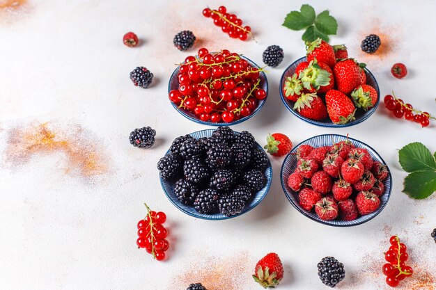 Diverses baies fraîches d'été, myrtilles, groseilles rouges, fraises, mûres, vue de dessus.