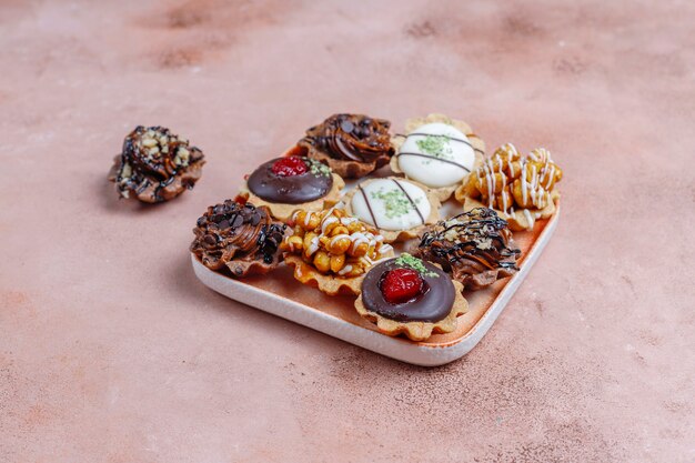 Diverses mini tartelettes maison aux noix et crème au chocolat.