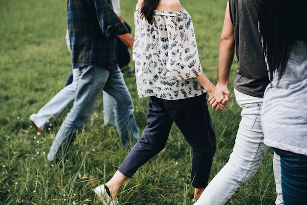 Diverses personnes se tenant la main et courir dans le parc