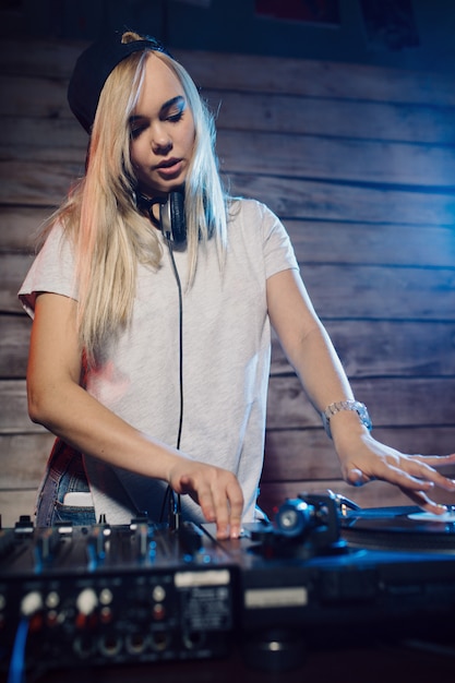 Photo gratuite dj mignon femme s'amusant à jouer de la musique à la fête du club