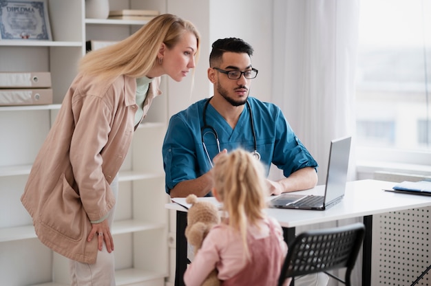 Photo gratuite docteur faisant leur travail dans le bureau de pédiatrie