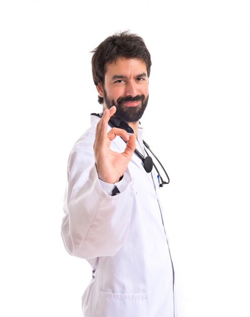 Docteur faisant Ok sign over white background