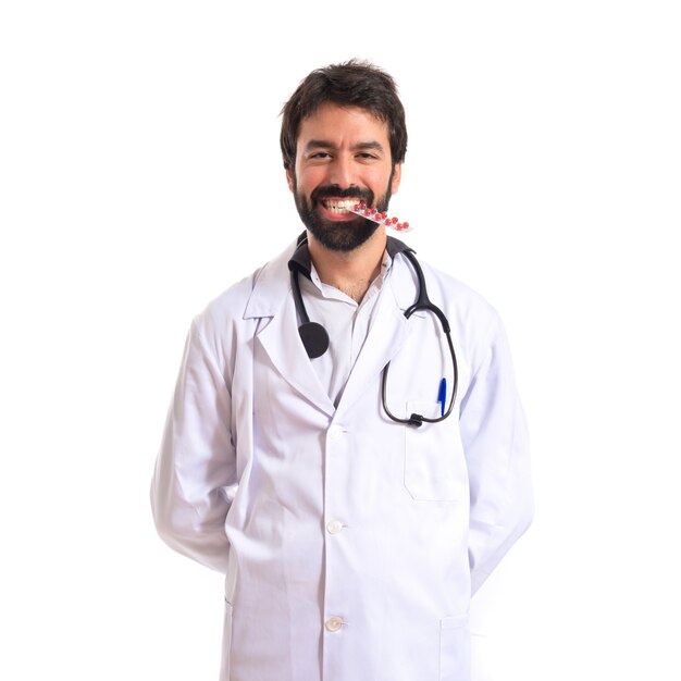 Docteur heureux avec des pilules sur fond blanc