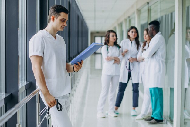 Docteur homme avec des documents de diagnostic dans le couloir de l'hôpital