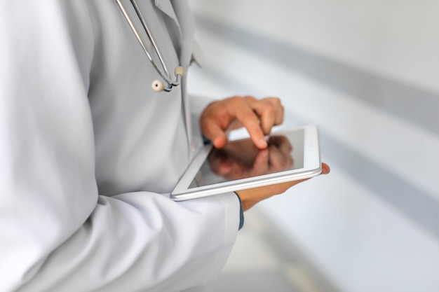 Docteur mains à l'aide d'une tablette moderne