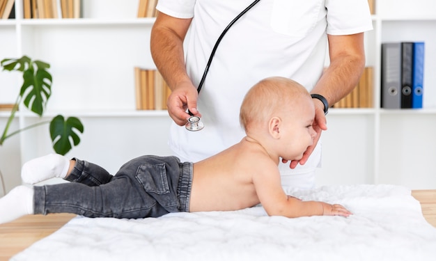 Docteur mains écoute bébé patient avec stéthoscope