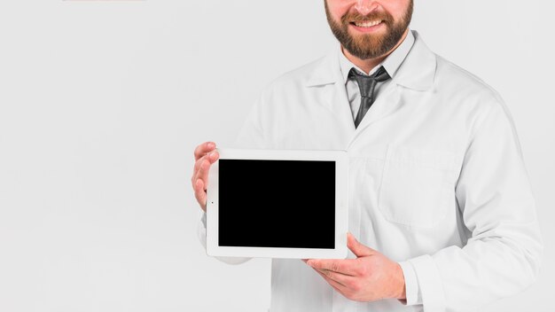 Docteur montrant une tablette et souriant