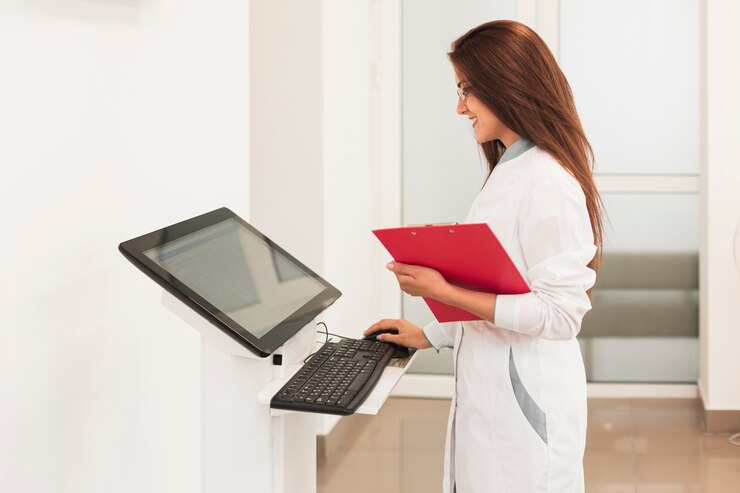 Photo gratuit docteur tenant presse-papiers et travaillant sur ordinateur