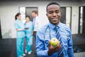 Photo gratuite docteur, tenue, pomme verte, dans, couloir hôpital