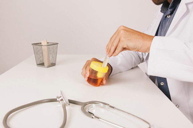 Docteur Travaillant Avec Un Test D'urine à Son Bureau