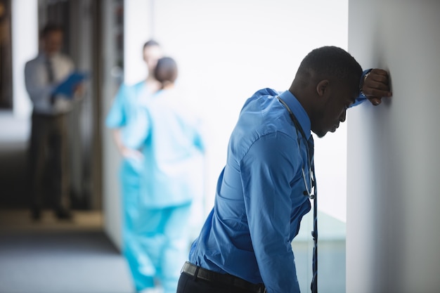 Docteur triste s'appuyant sur le mur