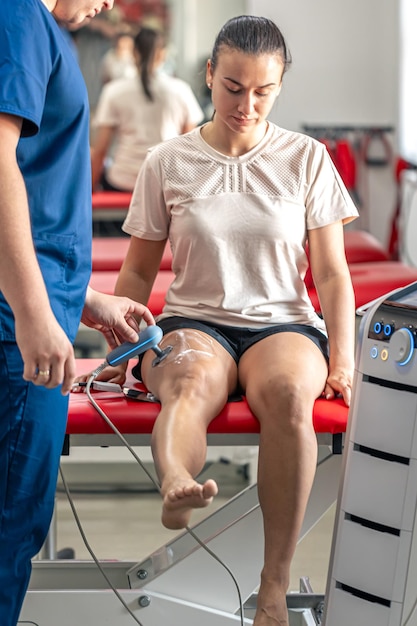 Photo gratuite docteur utilisant une machine pour traiter les articulations du genou d'un patient
