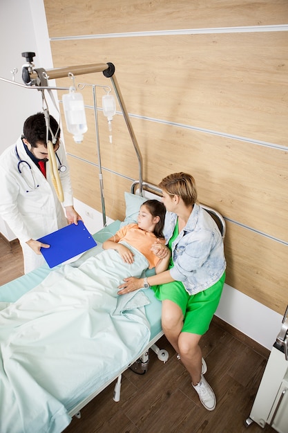 Docteur visitin patient girl in hospital room