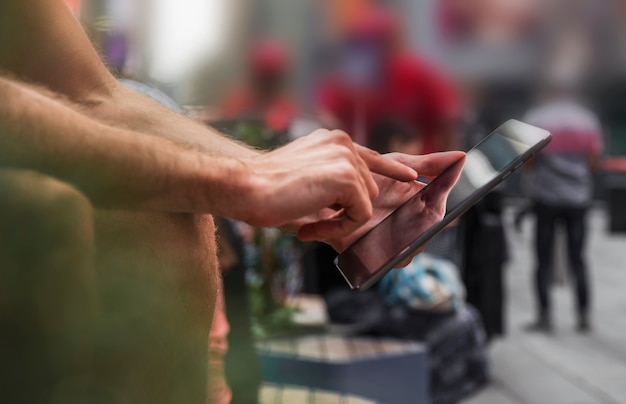 Un doigt d'homme touchant un écran de smartphone