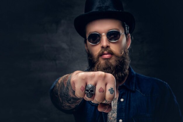 Les doigts du hipster tatoué en gros plan avec des anneaux.