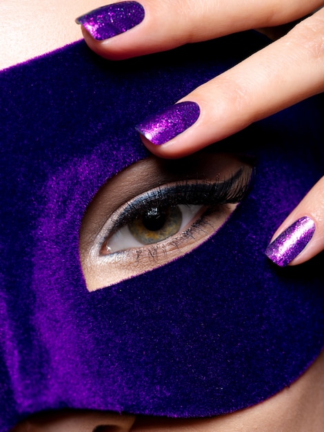 Photo gratuite les doigts de la femme avec des ongles bleus sur les yeux.