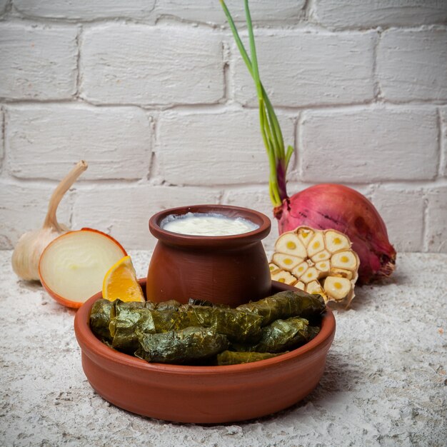 dolma avec du yaourt et de l'oignon et de l'ail dans des plats en argile