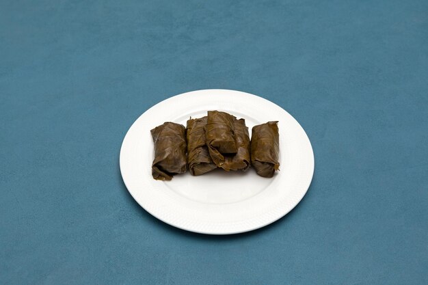 Dolma ou tolma avec de la viande sur une assiette blanche feuilles de vigne farcies