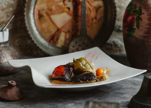 Photo gratuite domla de trois soeurs avec aubergine, tomate et poivron vert.