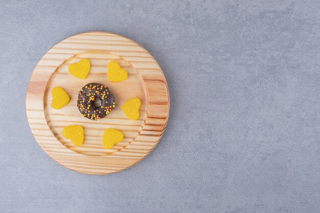 Donut et marmelades sur un plateau sur une surface en marbre