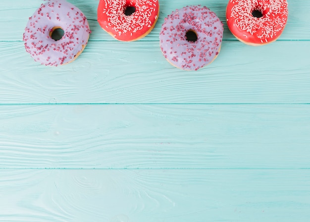 Donuts frais vue de dessus disposés sur une table en bois