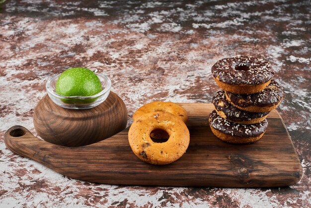 Donuts sur une planche de bois avec du chocolat.