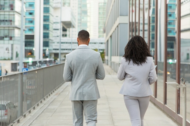 Dos de collègues de travail portant des costumes de bureau