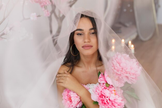 Douce dame sous le tulle tenant un bouquet de fleurs Photo de haute qualité