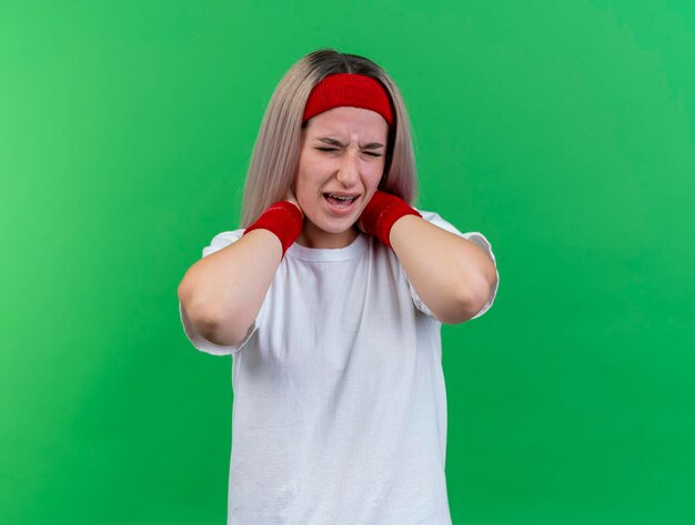 Douleur jeune fille sportive caucasienne avec des accolades portant un bandeau