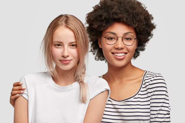 Doux tendre couple de femmes homosexuelles métisses étreindre et avoir des expressions amicales. Belle femme afro-américaine tient fermement sa charmante meilleure amie. Concept de personnes, d'émotions et d'amitié