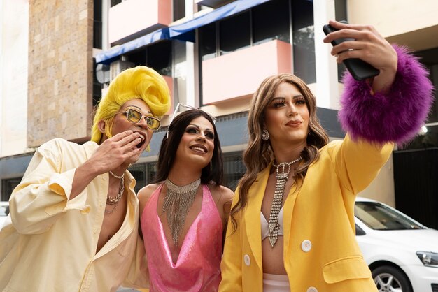 Drag Queens à tir moyen prenant un selfie