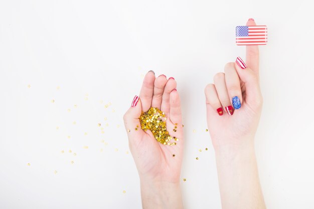 Drapeau américain sur le doigt et les confettis dans la main