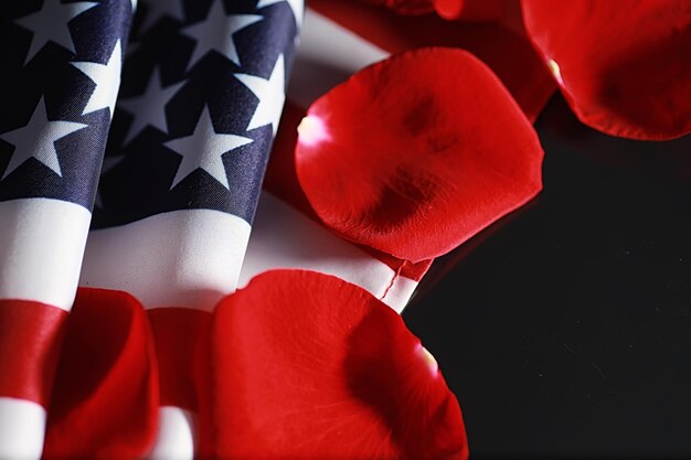 Drapeau américain et fleur rose sur la table. symbole des états-unis d'amérique et pétales rouges. patriotisme et mémoire.