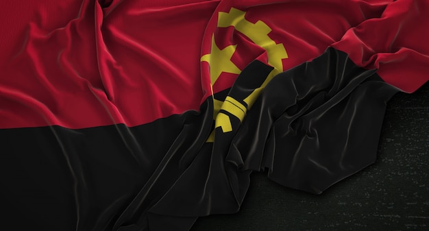 Drapeau de l&#39;Angola enroulé sur fond sombre 3D Render