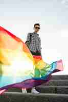 Photo gratuite drapeau arc-en-ciel dans la main de l'homosexuel
