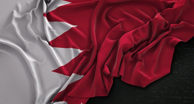 Photo gratuite le drapeau de bahrein est enroulé sur un fond sombre 3d render