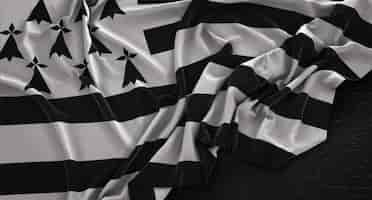 Photo gratuite le drapeau de bretagne enroulé sur un fond sombre 3d render