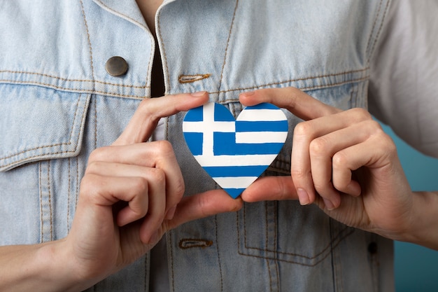 Drapeau de la grèce en forme de coeur tenu dans les mains