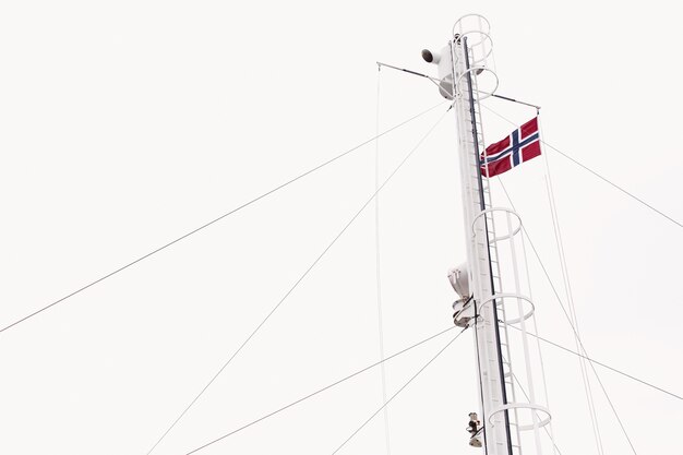 Drapeau de la Norvège sur le vent sous le ciel blanc