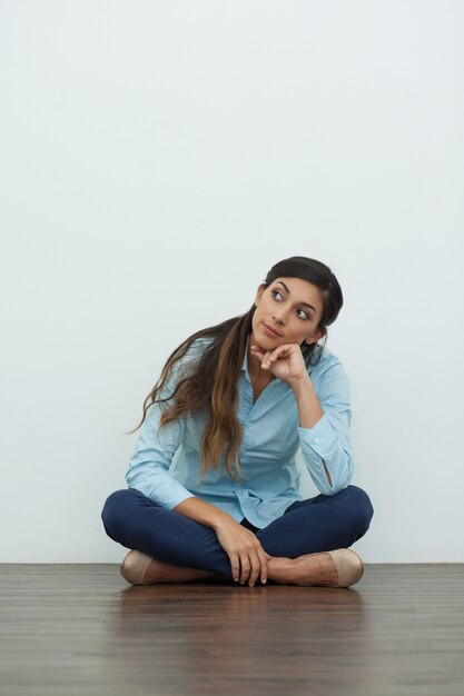 Dreamy Belle femme sur le plancher avec les jambes croisées