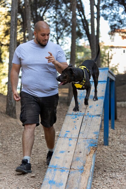 Dresseur de chiens mâles à l'extérieur avec un chien pendant la session