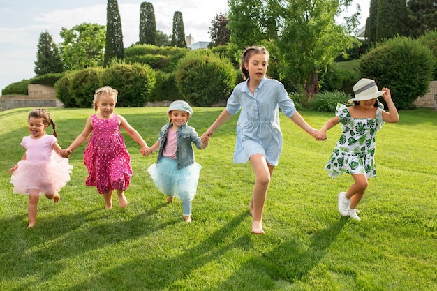 Drôle commence. Concept de mode pour enfants. Le groupe d'adolescents et de filles qui courent au parc. Vêtements colorés pour enfants, style de vie, concepts de couleurs à la mode.