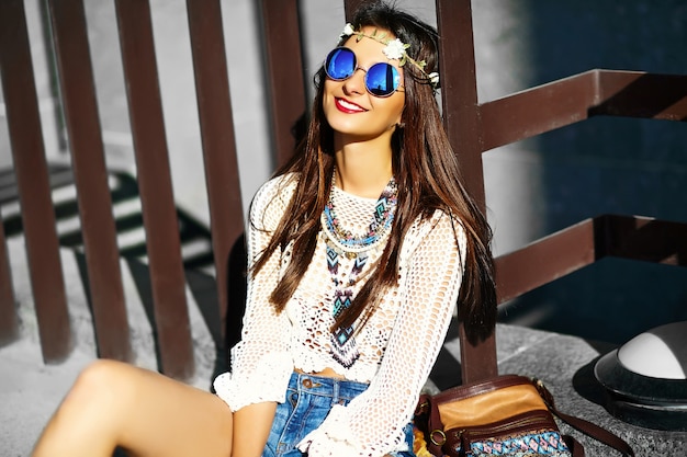 Drôle élégant sexy souriant belle jeune femme hippie modèle en été blanc frais vêtements hipster assis dans la rue