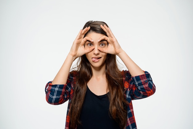 femme brune drôle avec un look attrayant, montre la langue, fait