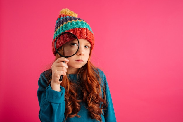 Photo gratuite drôle fille sérieuse regardant à travers la loupe à la caméra