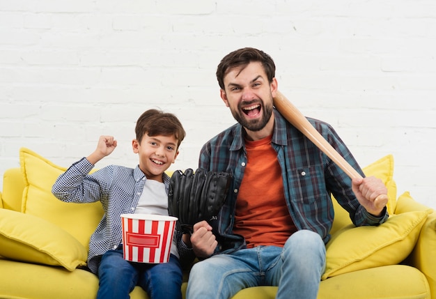 Drôle fils et père tenant une batte de baseball