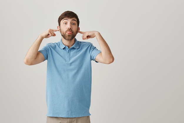 Drôle et idiot jeune homme barbu posant