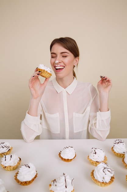 Drôle joyeuse jeune femme mangeant des gâteaux et s'amusant