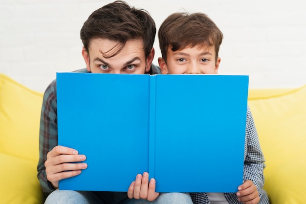 Drôle père et fils couvrant leurs visages