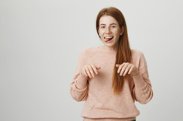 Drôle rousse fille souriante singe les pattes de chiot